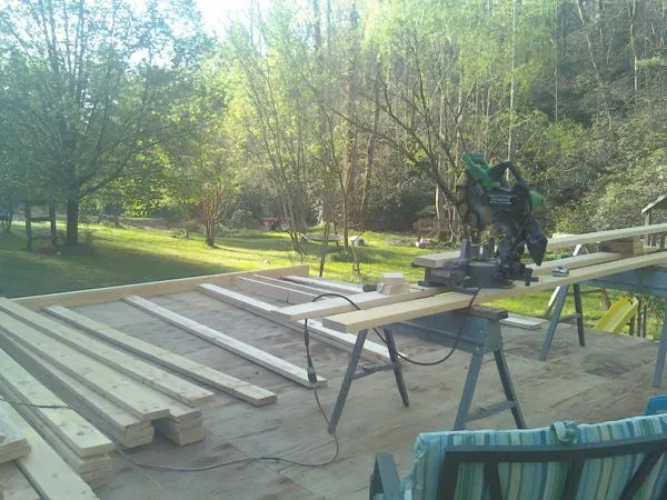 Miter saw and framing lumber on a deck under construction in Oakdale