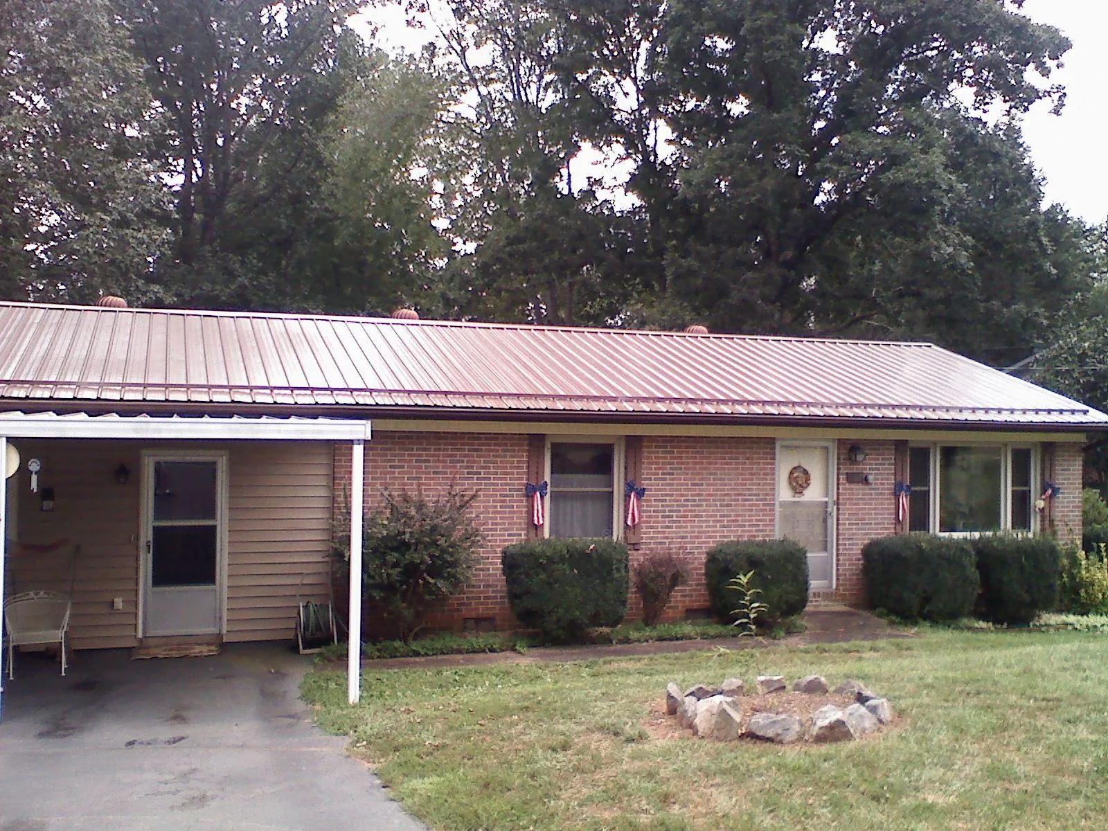 Bronze metal roof and carport on a brick ranch home — Roof Repair work by our crew in Oakdale